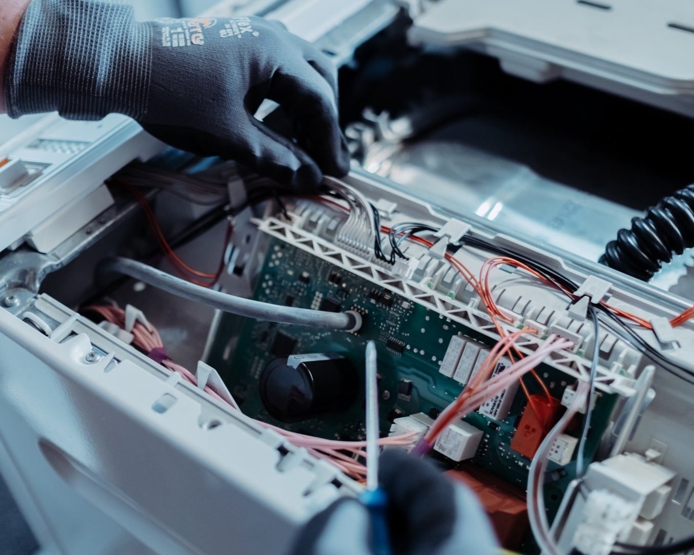 Techniker repariert Elektronikplatine eines Hausgeräts